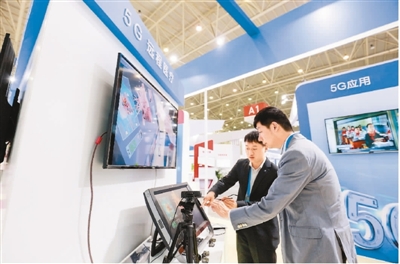 在第五届武汉国际电子商务暨“互联网+”产业博览会上，中国移动工作人员在5G技术体验展台为参观者介绍智能医疗设备。张海岩摄（人民视觉）